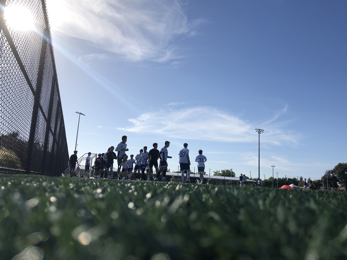 CalBlue players walking onto the field under a blue sky